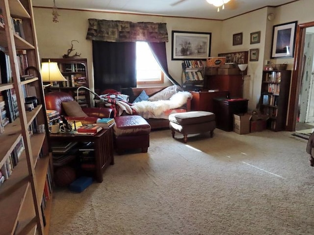 sitting room featuring carpet floors, ornamental molding, and ceiling fan