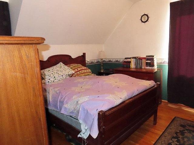 bedroom featuring vaulted ceiling and wood-type flooring