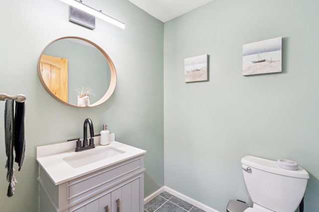 half bathroom with toilet, vanity, and baseboards