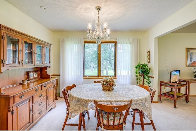 dining area with a notable chandelier and light colored carpet