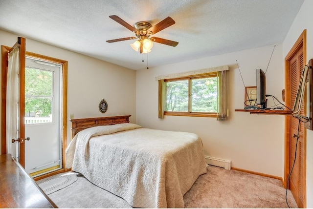 bedroom with baseboard heating, a textured ceiling, baseboards, and a ceiling fan