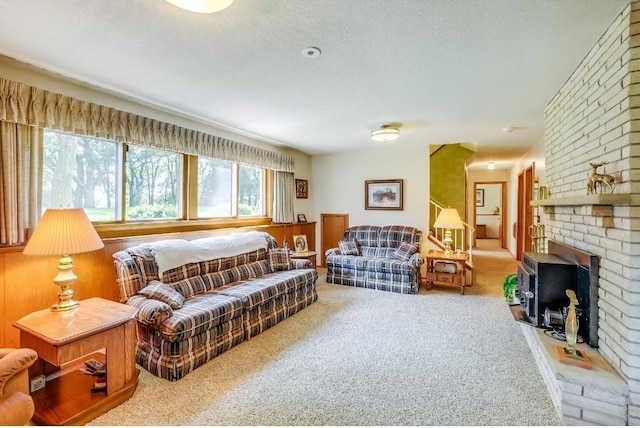 living room featuring carpet floors, a textured ceiling, and a fireplace