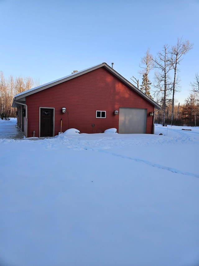 view of snowy exterior featuring a garage