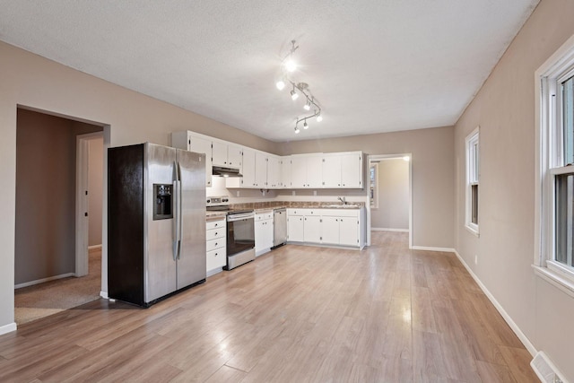 kitchen with stainless steel appliances, visible vents, light wood-style flooring, white cabinetry, and a textured ceiling