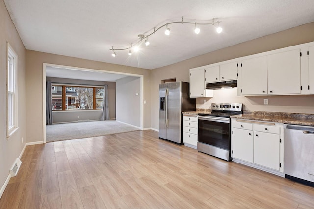 kitchen with under cabinet range hood, appliances with stainless steel finishes, white cabinets, and light wood-style floors