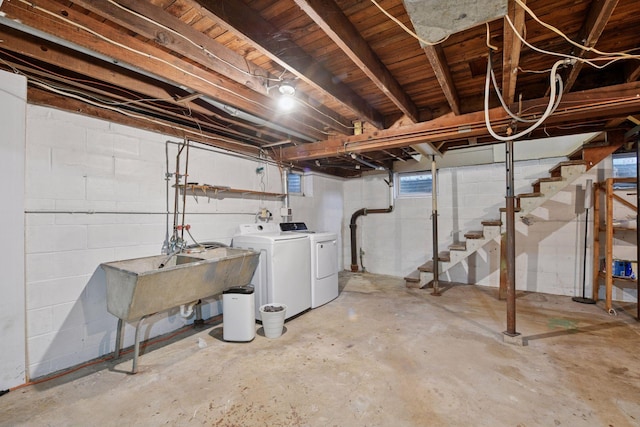 below grade area with a sink, stairway, and washing machine and dryer