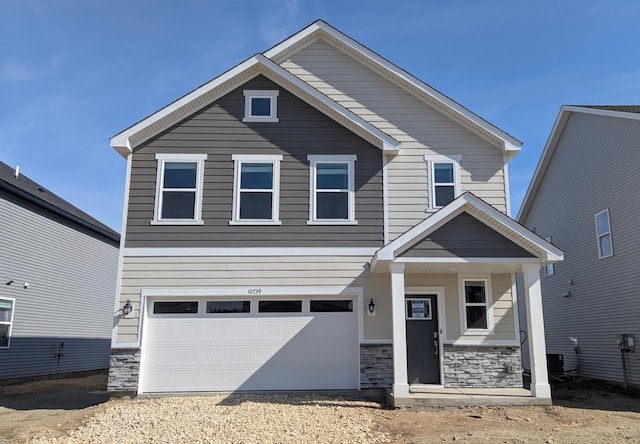 craftsman-style home featuring a garage and stone siding