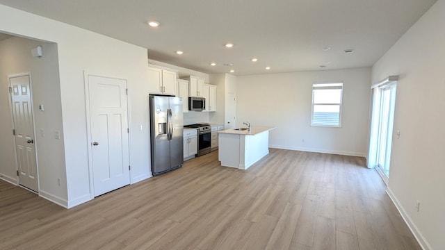 kitchen featuring light wood-style flooring, an island with sink, recessed lighting, white cabinets, and appliances with stainless steel finishes