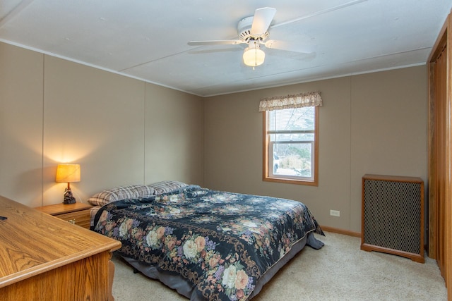 bedroom with light carpet, crown molding, radiator heating unit, and ceiling fan