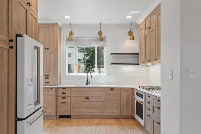 kitchen featuring appliances with stainless steel finishes, hanging light fixtures, light countertops, open shelves, and a sink