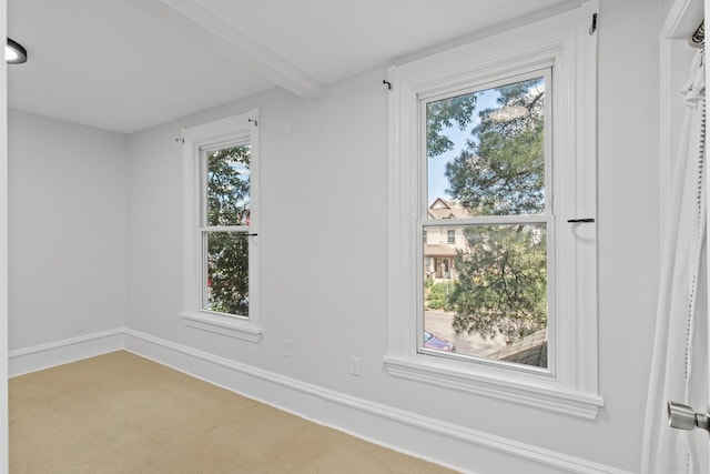 spare room with beamed ceiling and baseboards