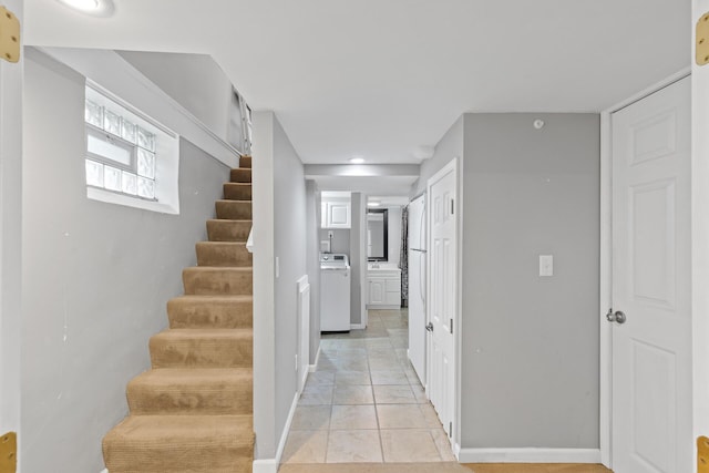 interior space with baseboards, washer / dryer, and tile patterned floors