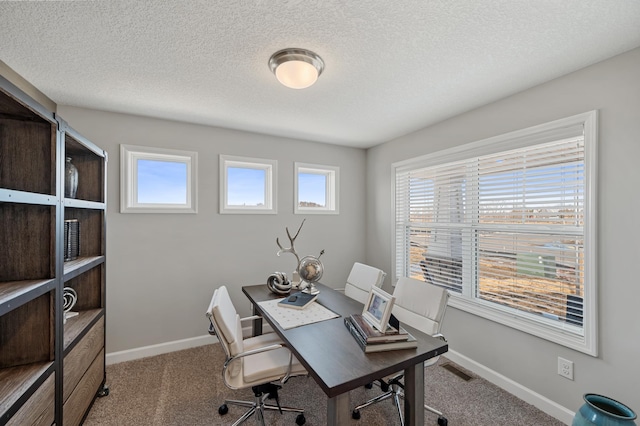 carpeted office featuring a textured ceiling