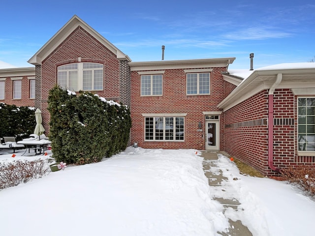 view of snow covered back of property