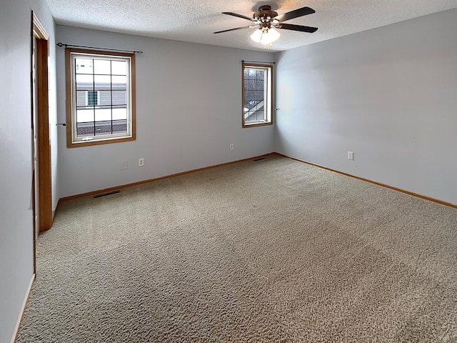 carpeted spare room with ceiling fan and a textured ceiling