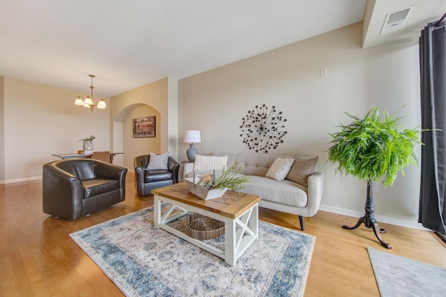 living room featuring light wood-type flooring and a chandelier