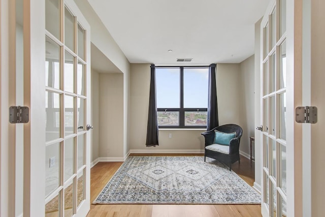 sitting room with french doors and hardwood / wood-style flooring