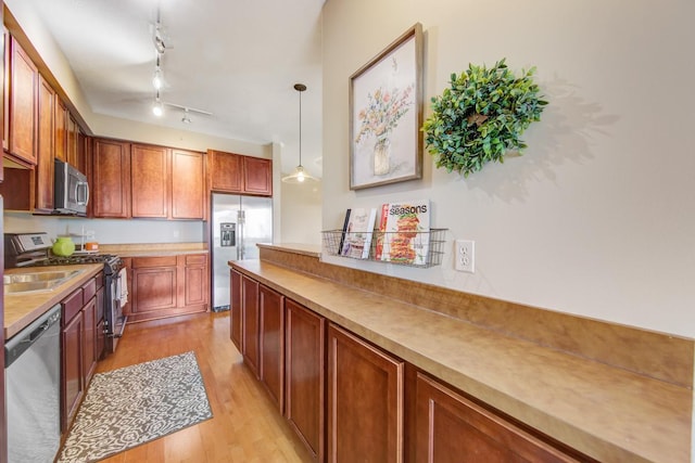 kitchen featuring light hardwood / wood-style flooring, stainless steel appliances, and pendant lighting