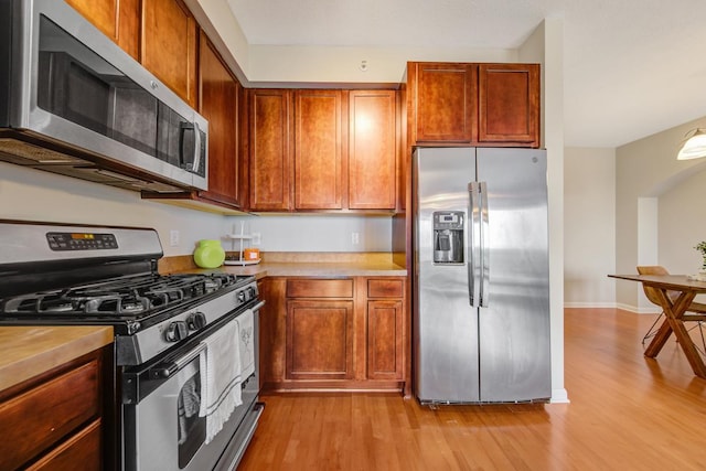 kitchen featuring appliances with stainless steel finishes and light hardwood / wood-style flooring