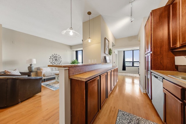 kitchen featuring kitchen peninsula, hanging light fixtures, light hardwood / wood-style flooring, dishwasher, and rail lighting