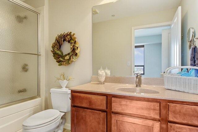 full bathroom with vanity, shower / bath combination with glass door, and toilet