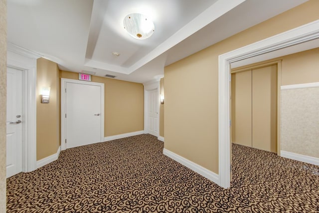 hallway featuring a tray ceiling