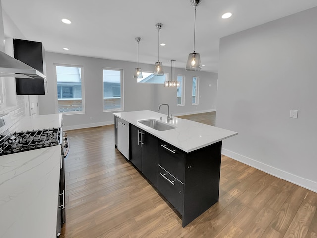 1447 Juliet Ave, Saint Paul, MN 55105 - kitchen with dark cabinets, a sink, stainless steel appliances, wall chimney exhaust hood, and baseboards