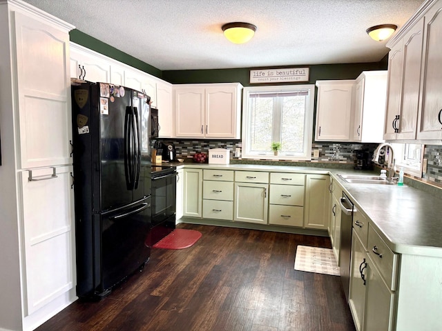 kitchen with sink, backsplash, dark hardwood / wood-style flooring, black appliances, and green cabinetry