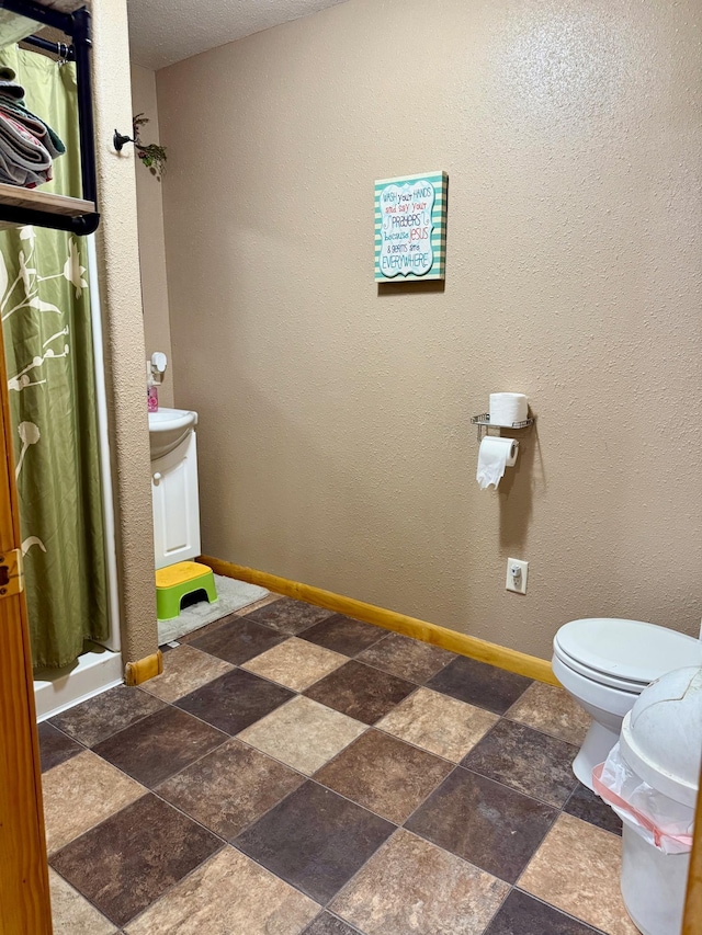 bathroom featuring a shower with shower curtain and toilet