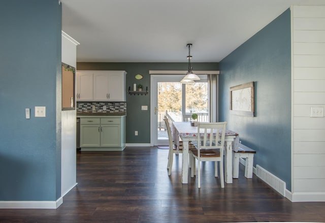 dining area with visible vents, dark wood-style flooring, and baseboards