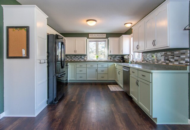 kitchen with dark wood-style floors, freestanding refrigerator, backsplash, stainless steel dishwasher, and a sink