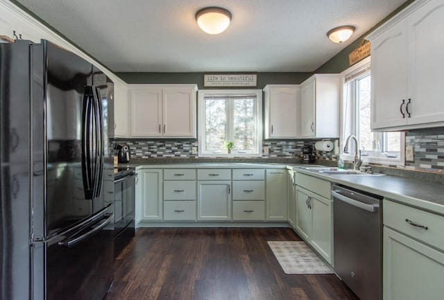 kitchen with a sink, black appliances, and backsplash