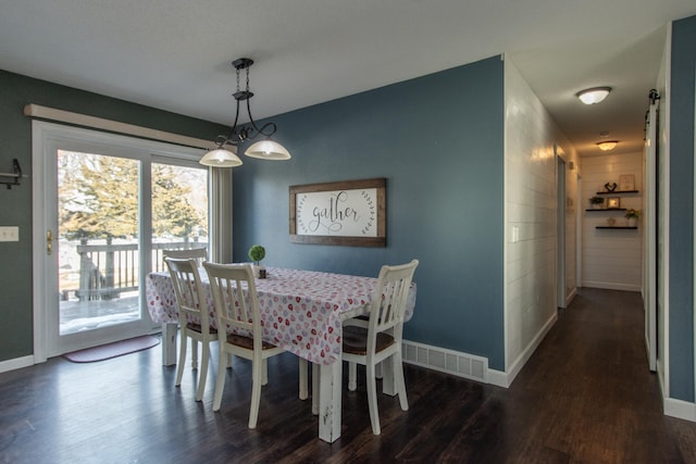 dining space with dark wood-style flooring, visible vents, and baseboards