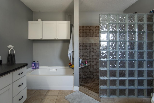bathroom featuring tile patterned floors, a garden tub, a textured ceiling, and walk in shower
