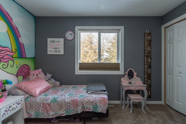 carpeted bedroom featuring a closet and baseboards