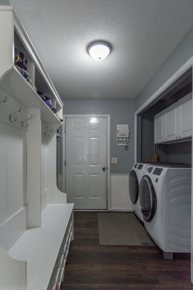 laundry room with dark wood finished floors, washer and clothes dryer, a textured ceiling, and cabinet space