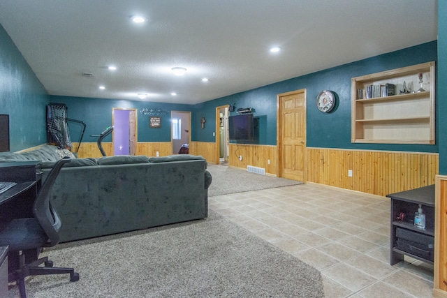 living area featuring visible vents, a wainscoted wall, recessed lighting, and wood walls
