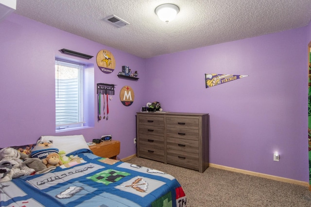 bedroom with a textured ceiling, visible vents, and carpet