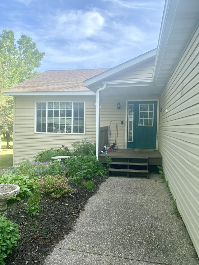 entrance to property featuring a shingled roof