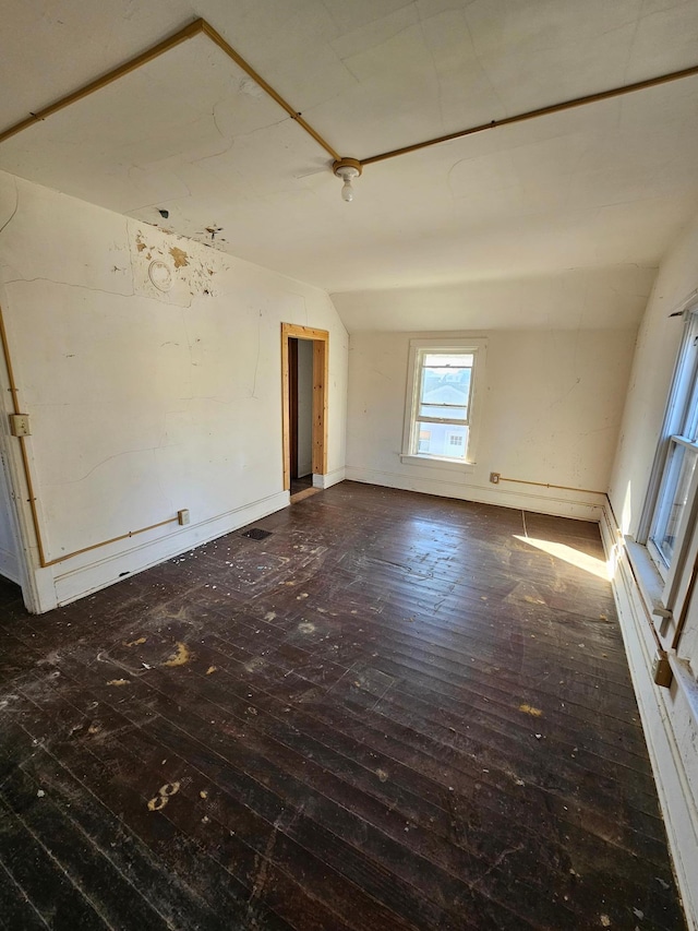 empty room with lofted ceiling and dark hardwood / wood-style flooring