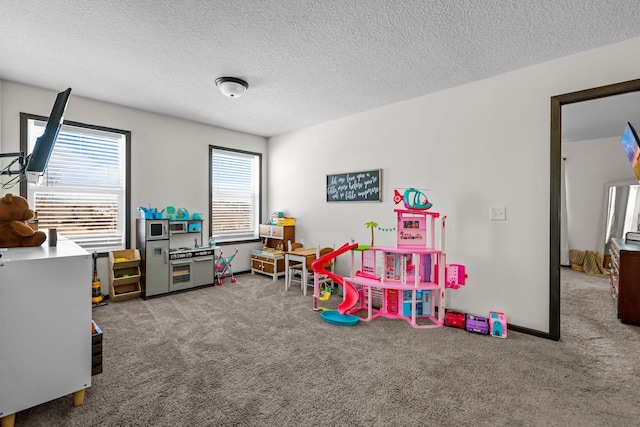 recreation room featuring light colored carpet and a textured ceiling