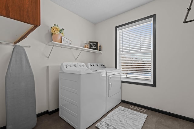 washroom featuring visible vents, baseboards, and washer and dryer