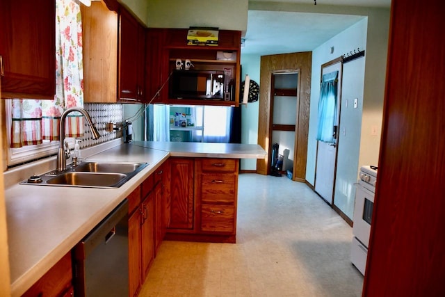 kitchen featuring black microwave, a peninsula, a sink, light countertops, and stainless steel dishwasher