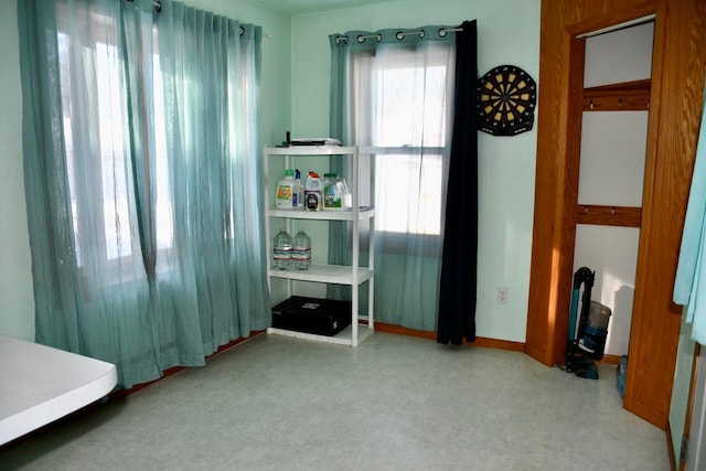 bedroom with light floors and baseboards