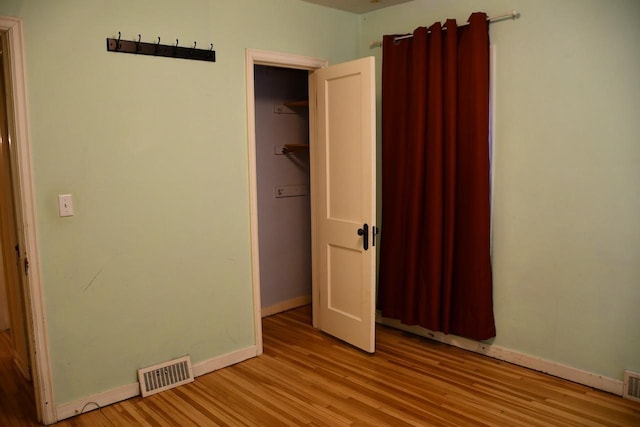 unfurnished bedroom with light wood-type flooring, visible vents, and baseboards