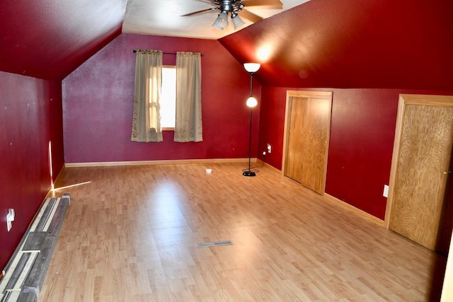 bonus room featuring light wood-style floors, lofted ceiling, ceiling fan, and baseboards