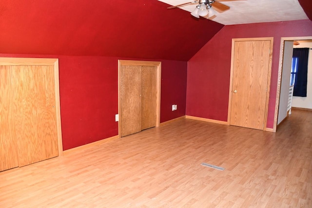 additional living space featuring lofted ceiling, ceiling fan, wood finished floors, and visible vents