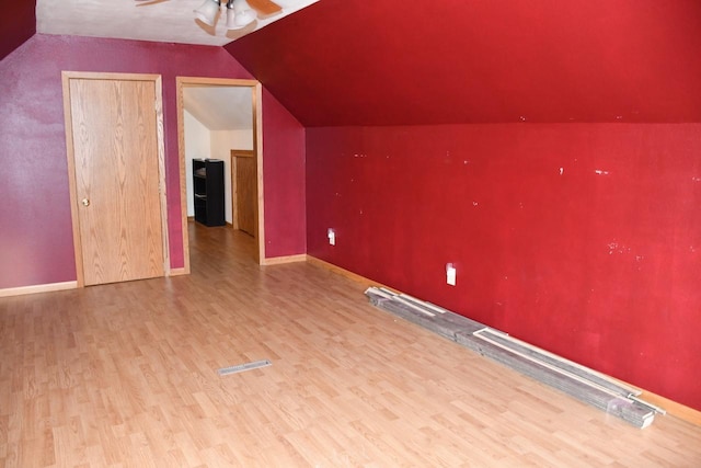 additional living space with lofted ceiling, ceiling fan, baseboards, and wood finished floors