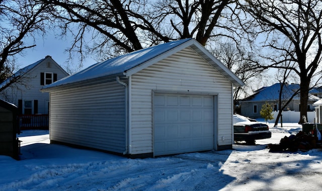 snow covered garage featuring a garage