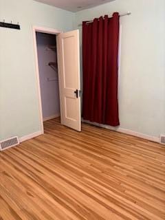 unfurnished bedroom with baseboards, visible vents, and light wood-style floors